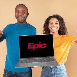 Excited black couple holding and showing laptop with black screen, presenting and pointing at gadget with blank space for mockup, peach studio background